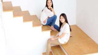 女性二人が階段に座っている