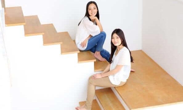 女性二人が階段に座っている